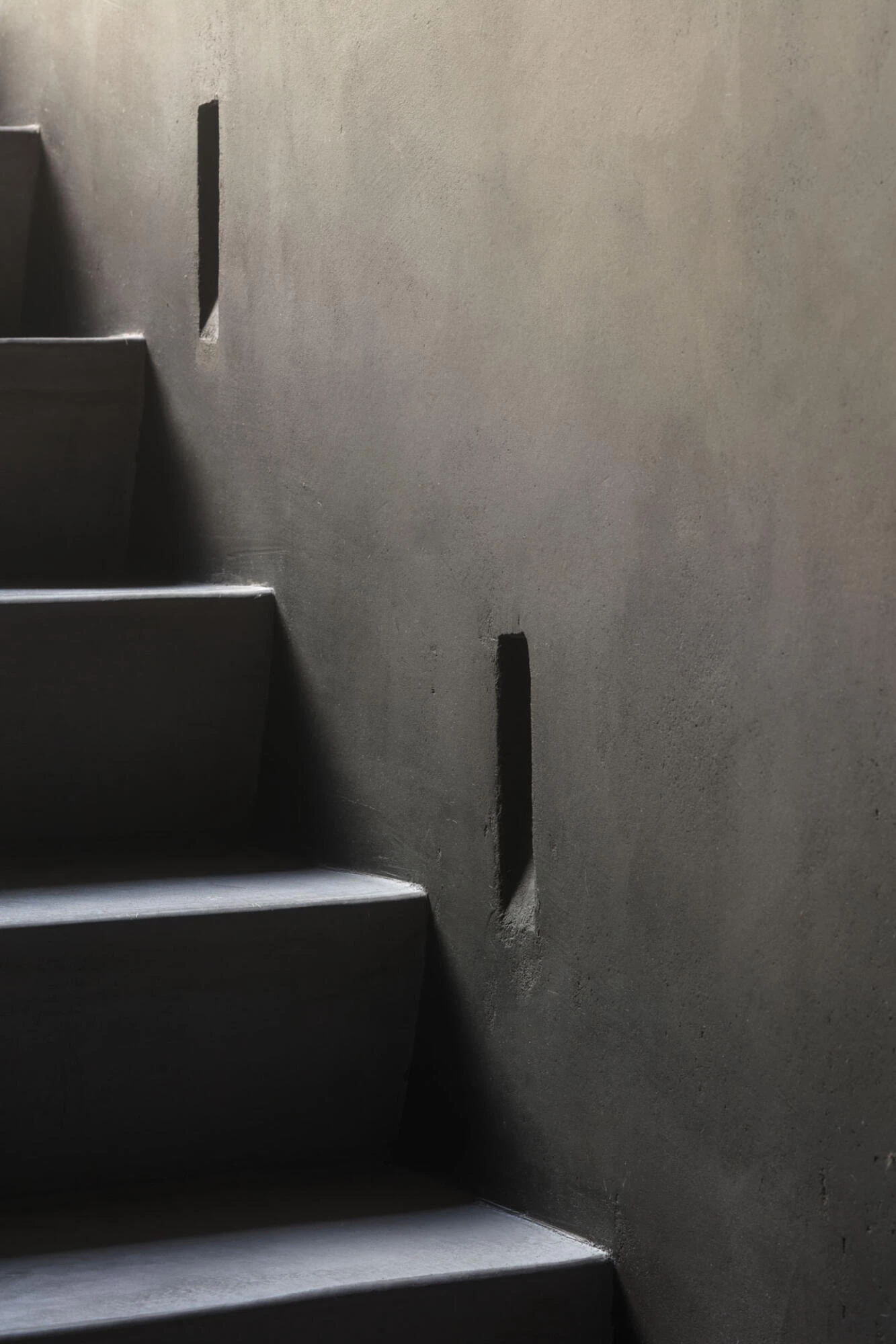 Stairs with black Thalostuc on wall in interior of K2A